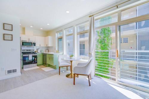 a kitchen with a table and chairs and windows at 103 Belltown Modern and Bright in the Heart of Belltown Queen Bed in Seattle