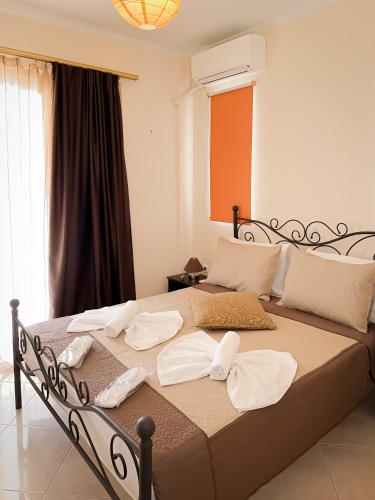 un letto con asciugamani in una camera da letto di Sun n' Salt II Apartment a Tolo