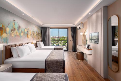 a hotel room with two beds and a window at SEAPHORIA BEACH HOTEL & Spa - by Mir'Amor-Ultra All Inclusive in Antalya