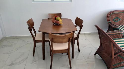 a wooden table with a bowl of fruit on it at Aparta Hotel Marymar in Nagua