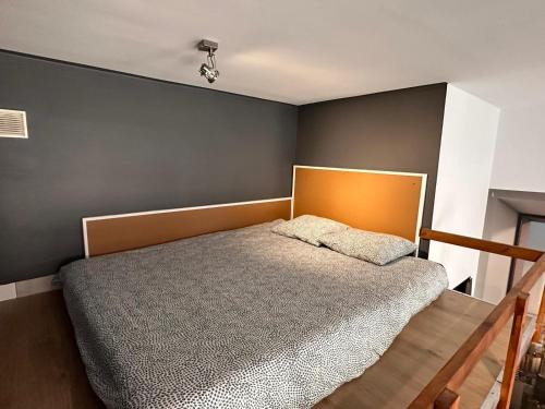 sypialnia z łóżkiem i szarą ścianą w obiekcie Apartamenty Gołębia-Genius w Poznaniu