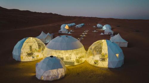 a group of tents in the desert at night at Luxury Desert Camp Oman in Al Wāşil