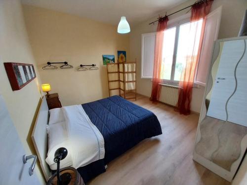 una camera da letto con un letto blu e una finestra di Ciclamino fori Porta Pispini 2 a Siena