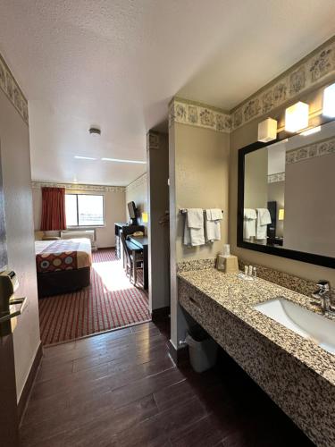 a hotel room with a bathroom with a sink and a bed at Rodeway Inn & Suites Madison East in Madison