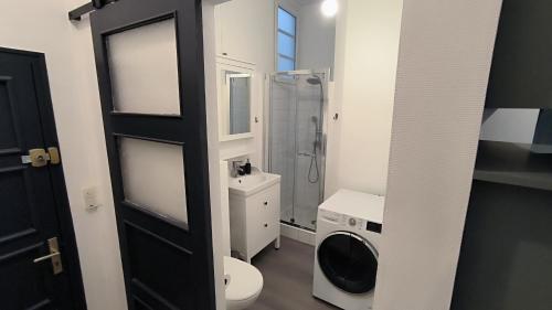 Un baño con inodoro y lavadora. en cocooning centre Dinan, en Dinan
