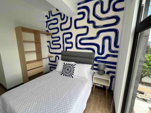 a bedroom with a bed with a blue and white patterned wall at Sefje - Relax in the City in Guatemala
