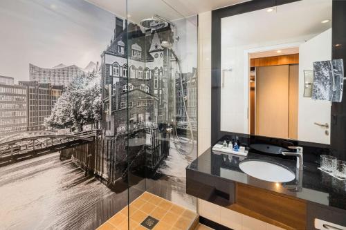 a bathroom with a wall mural of a building at Radisson Blu Hotel, Hamburg Airport in Hamburg