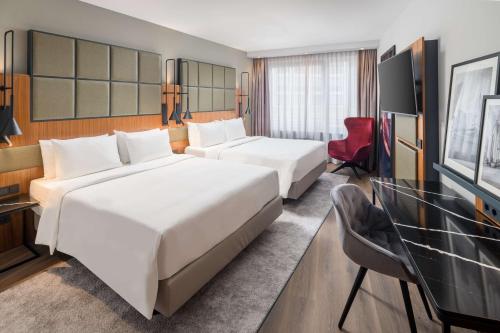 a hotel room with two beds and a television at Radisson Blu Hotel, Hamburg Airport in Hamburg