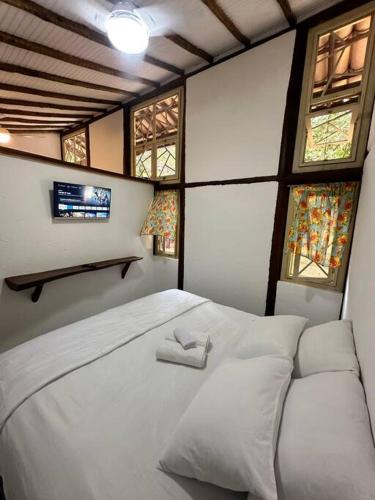 una camera da letto con un letto con due asciugamani bianchi di Chalezim VIP 3 - Chalé Privativo com Hidro - Serra Cipó a Santana do Riacho