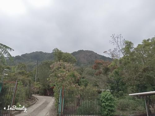 een onverharde weg met een hek en bergen op de achtergrond bij Casa kadosh. in Antón