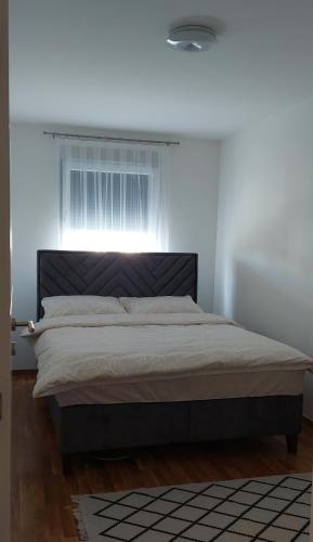 a bedroom with a large bed with a window at Garden Doboj in Doboj