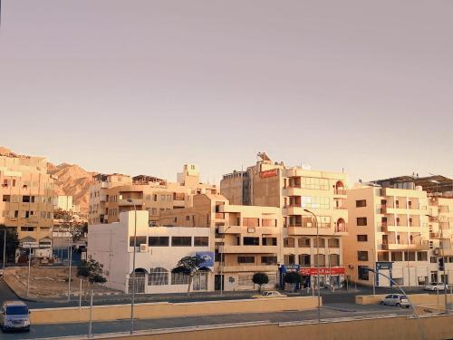 a group of buildings in a city with a street at Amir Palace Hotel in Aqaba