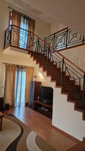 a living room with a staircase and a television at Maria Vagueira BeachHouse in Vagos