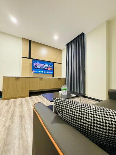 a living room with a couch and a flat screen tv at STAR HOTEL in Tawau