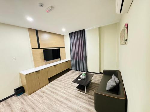 a hotel room with a couch and a tv at STAR HOTEL in Tawau