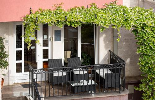 a balcony with chairs and a pergola at Apartments Ivona in Budva