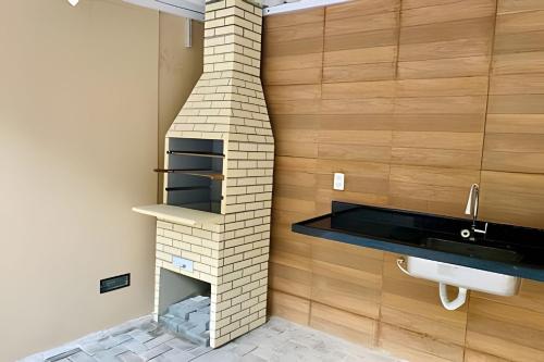 uma lareira de tijolos na casa de banho com lavatório em Apto 3 quartos com piscina e pertinho da praia. em João Pessoa