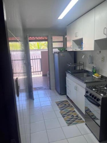 CamassariにあるVilage 3/4 aconchegante em Guarajubaのキッチン(シンク、コンロ付)