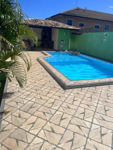 CamassariにあるVilage 3/4 aconchegante em Guarajubaの家の前の青い大型スイミングプール