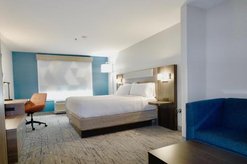 a bedroom with a bed and a desk and a chair at Holiday Inn Express & Suites - Smithfield/Selma by IHG in Smithfield