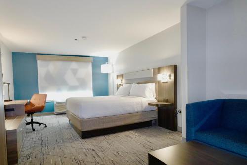 a bedroom with a bed and a desk and a chair at Holiday Inn Express & Suites - Smithfield/Selma, an IHG Hotel in Smithfield