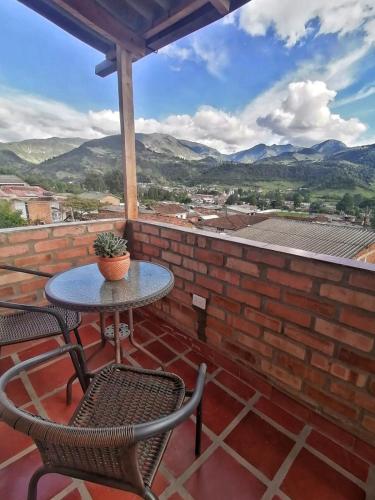 a table and chairs on a patio with mountains in the background at villa luz de vida in Silvia