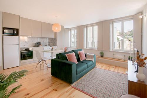 uma sala de estar com um sofá verde e uma cozinha em NEW - Bright Studio in Santa Catarina no Porto