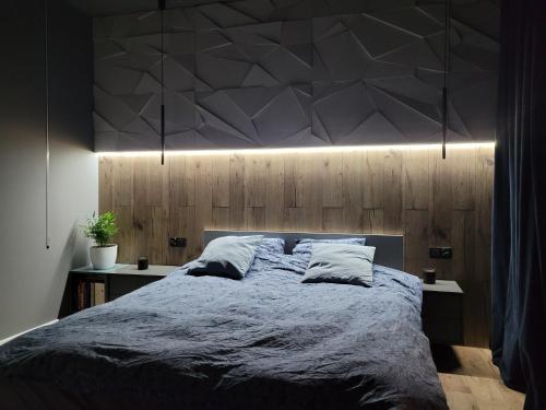 a bedroom with a large bed with lights above it at Modern apartment with spacious backyard by Matt in Warsaw