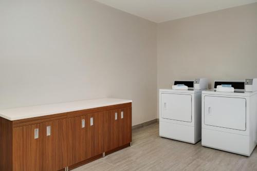 two washing machines and a counter in a room at Wingate by Wyndham Williamsburg in Williamsburg