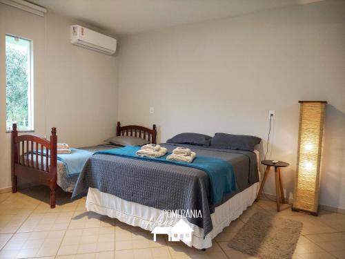 1 dormitorio con 2 camas y ventana en Pomerânia Haus en Pomerode