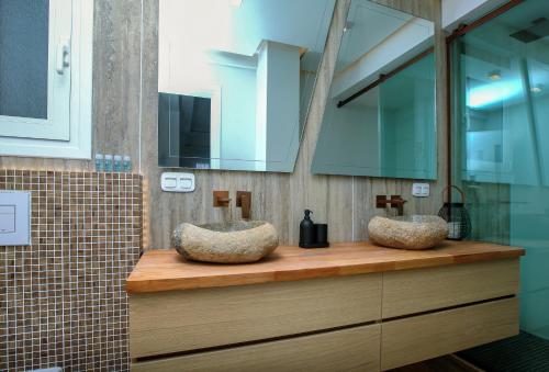 two sinks on a wooden counter in a bathroom at Elysian Haven in Athens
