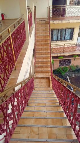 a staircase leading to a building with red metal railing at Moifaka Studio Hotel in Moroni