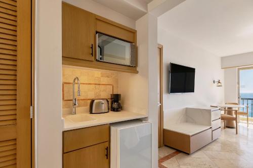 a kitchen with a sink and a microwave at Grand Fiesta Americana Los Cabos All Inclusive Golf & Spa in Cabo San Lucas