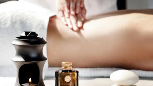 a person laying in a bed with a bottle of perfume at ANA InterContinental Appi Kogen Resort by IHG in Hachimantai