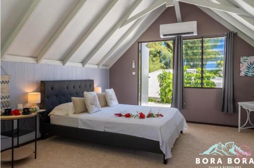 波拉波拉的住宿－Matira Sunset House N659 DTO-MT，一间卧室,床上放着鲜花