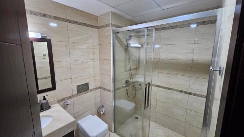 uma casa de banho com um chuveiro, um WC e um lavatório. em Luxury villa 4 bedroom with pool access em Ras al-Khaimah