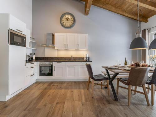 a kitchen with a table and a clock on the wall at Luxury Tauern Suite Walchen-Kaprun 7 in Piesendorf