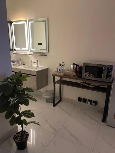 a bathroom with a sink and a microwave at Al Jadeed Istudio In Al Jubaylah in Al ‘Uyaynah