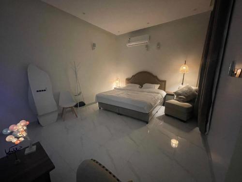 a bedroom with a bed and a chair in it at Al Jadeed Istudio In Al Jubaylah in Al ‘Uyaynah