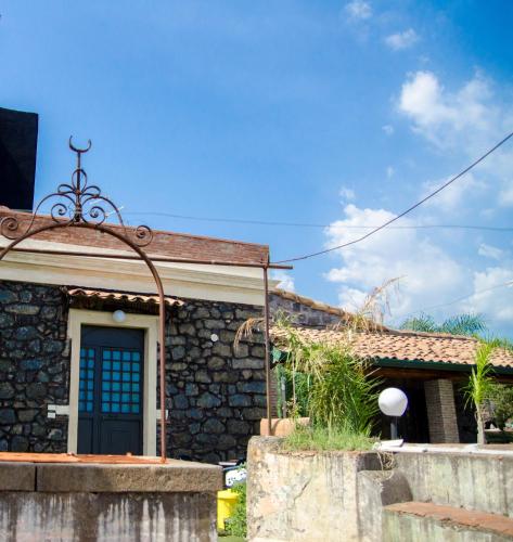 a stone house with a blue door at Il Rustico in Pozzillo