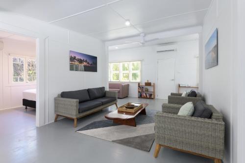 Sala de estar con 2 sofás y mesa en Coastal Chill, en Port Douglas