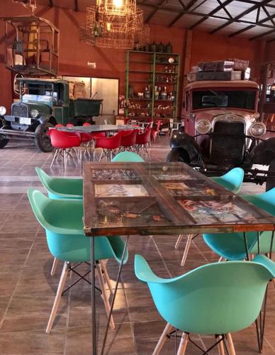 Una mesa y sillas en una habitación con un camión viejo. en Posada de campo Mamúll Mapú, en Rancul