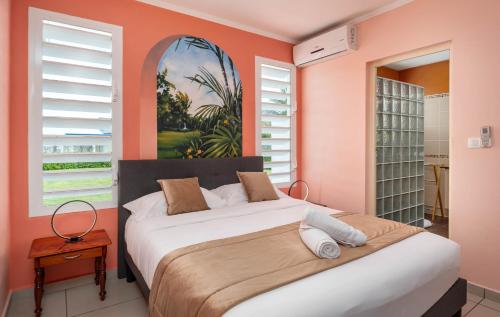 ein Schlafzimmer mit einem Bett und einem Wandgemälde in der Unterkunft La villa de Lynko in Le Moule