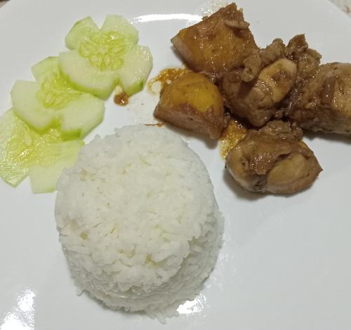 a white plate with rice and other foods on it at Rovi Homestay in Coron