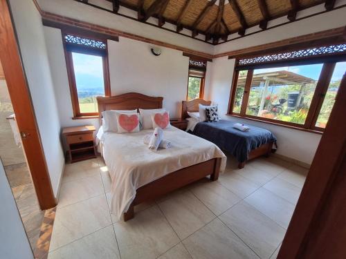 una camera con due letti in una stanza con finestre di Casa Campestre Flores Amarillas a Villa de Leyva
