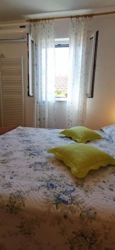 a bedroom with a large bed with a window at Apartments FANI KANUN in Bol