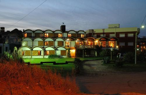 un gran edificio por la noche con sus luces encendidas en Hosteria Querandi en Villa Gesell