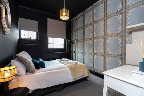 a bedroom with a bed and a wall of glass doors at Dickens Nook in Hartlepool