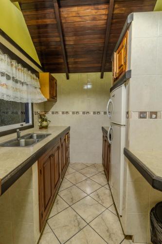 een keuken met een wastafel en een koelkast bij Casa en la colonia Tovar in El Tigre