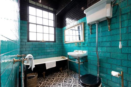 a blue bathroom with a tub and a sink at Dickens Nook in Hartlepool
